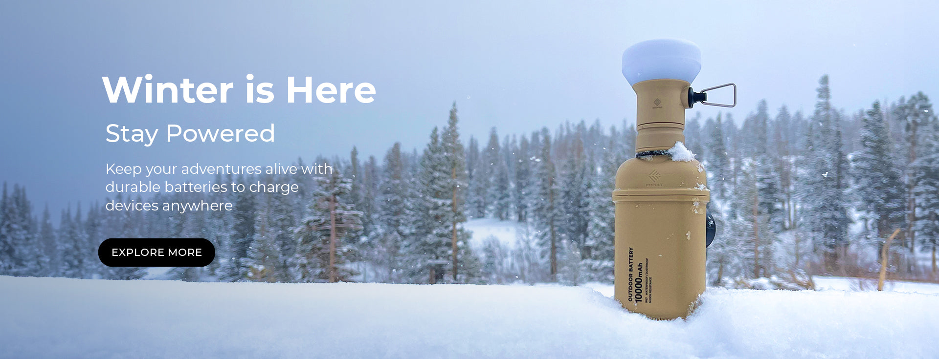 image of a snowy scene with evergreen trees and a beige NESTOUT 10000 mAh  power bank with the LAMP-1 attachment on right | left text overlay reads: winter is here | stay powered | keep your adventures alive with durable batteries to charge devices anywhere | EXPLORE MORE