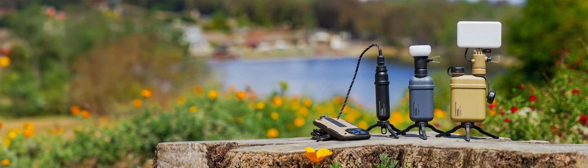A collection of outdoor batteries with lighting accessories set against a scenic lake background.