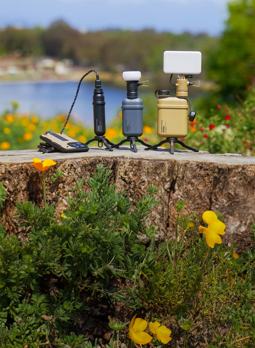 A collection of outdoor batteries with lighting accessories set against a scenic lake background.
