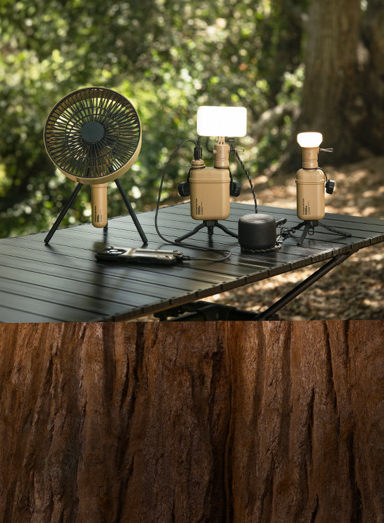 Outdoor setting with a small table with outdoor batteries, light, and fan on a table.