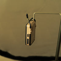 Beige co alarm being hung from a pole with a hook on the end