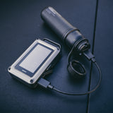 CO monitor being charged by a 5000mAH NESTOUT power bank on a dark surface
