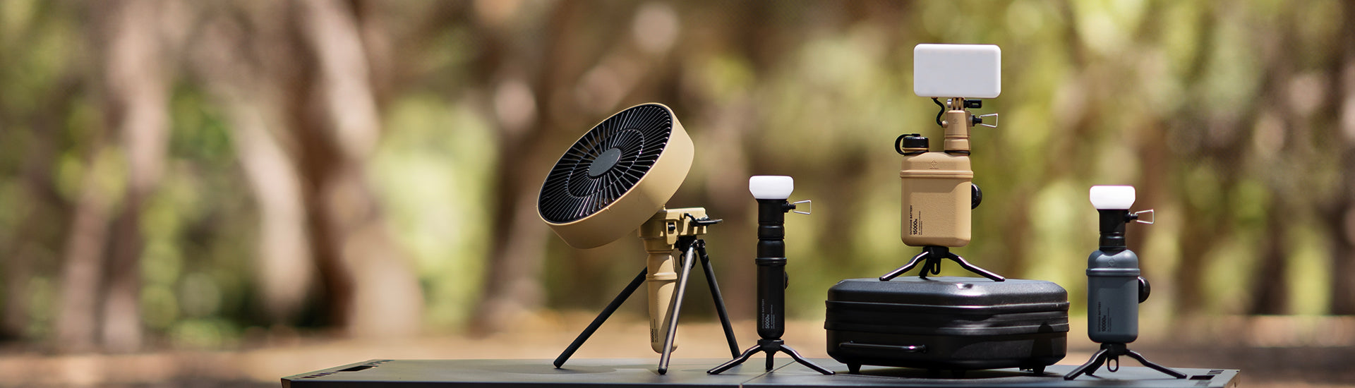 15k, 10k, 5k power banks with light and lamp attachments and a 5k with fan attachment and a gear case on a table outdoors