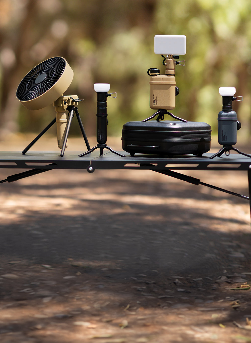 15k, 10k, 5k power banks with light and lamp attachments and a 5k with fan attachment and a gear case on a table outdoors