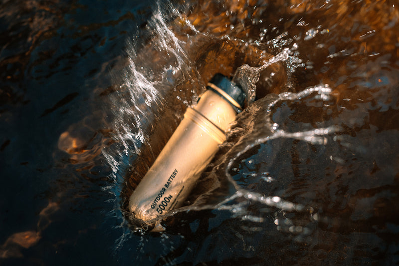 5000mAh rugged outdoor battery dropped into water with splashes, water-resistant power bank for outdoor use.