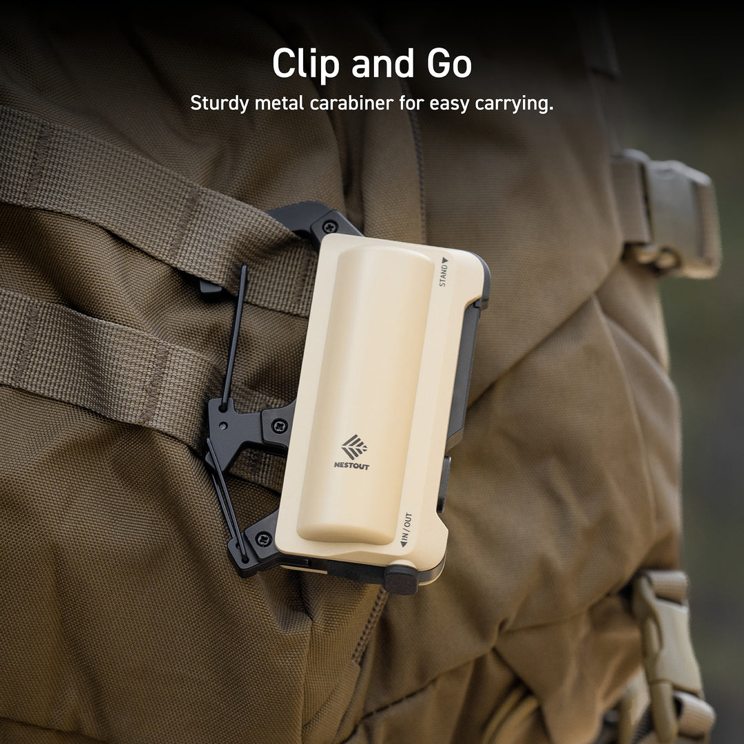 Text overlay in top middle center reads: Clip and Go: sturdy metal carabiner for easy carrying | zoomed image of a beige power bank on a khaki colored tactical backpack