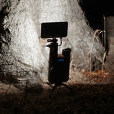 image of turned on nestout beige flash attached to 15k battery in the dark in front of a tree