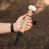 Image of hand holding nestout beige lamp with spacer attached 5k battery connected and tripod attached