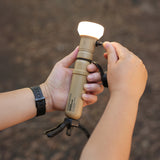 Image of hands turning on nestout beige lamp with spacer attached connected to 5k beige battery and tripod attached