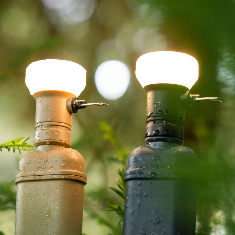 Image of wet turned on nestout beige lamp and black lamp with spacer attached to 10k batteries in the woods