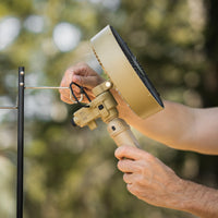 image of nestout beige fan with black tripod attached being hooked on