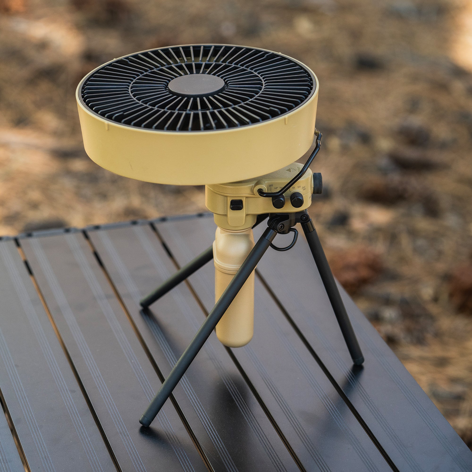image of nestout beige fan facing upward with black tripod attached