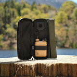 image of the nestout olive green 2 solar panel unfolded and the 15k beige battery connected to the USB connector resting on a tree stump at Jenks Lake

