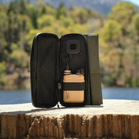 image of the nestout olive green 2 solar panel unfolded and the 15k beige battery connected to the USB connector resting on a tree stump at Jenks Lake
