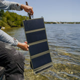 image of fisherman holding open towards the sun the nestout olive green 4 panel solar charger