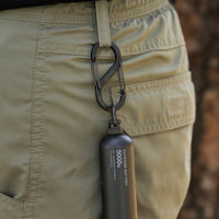 black carabiner attached to a belt loop and it has a black 5k power bank attached.