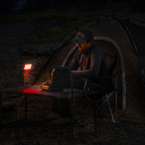 person outdoors with a 10k power bank with a flash-1 attachment and red filter light attached at night