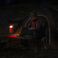 person outdoors with a 10k power bank with a flash-1 attachment and red filter light attached at night