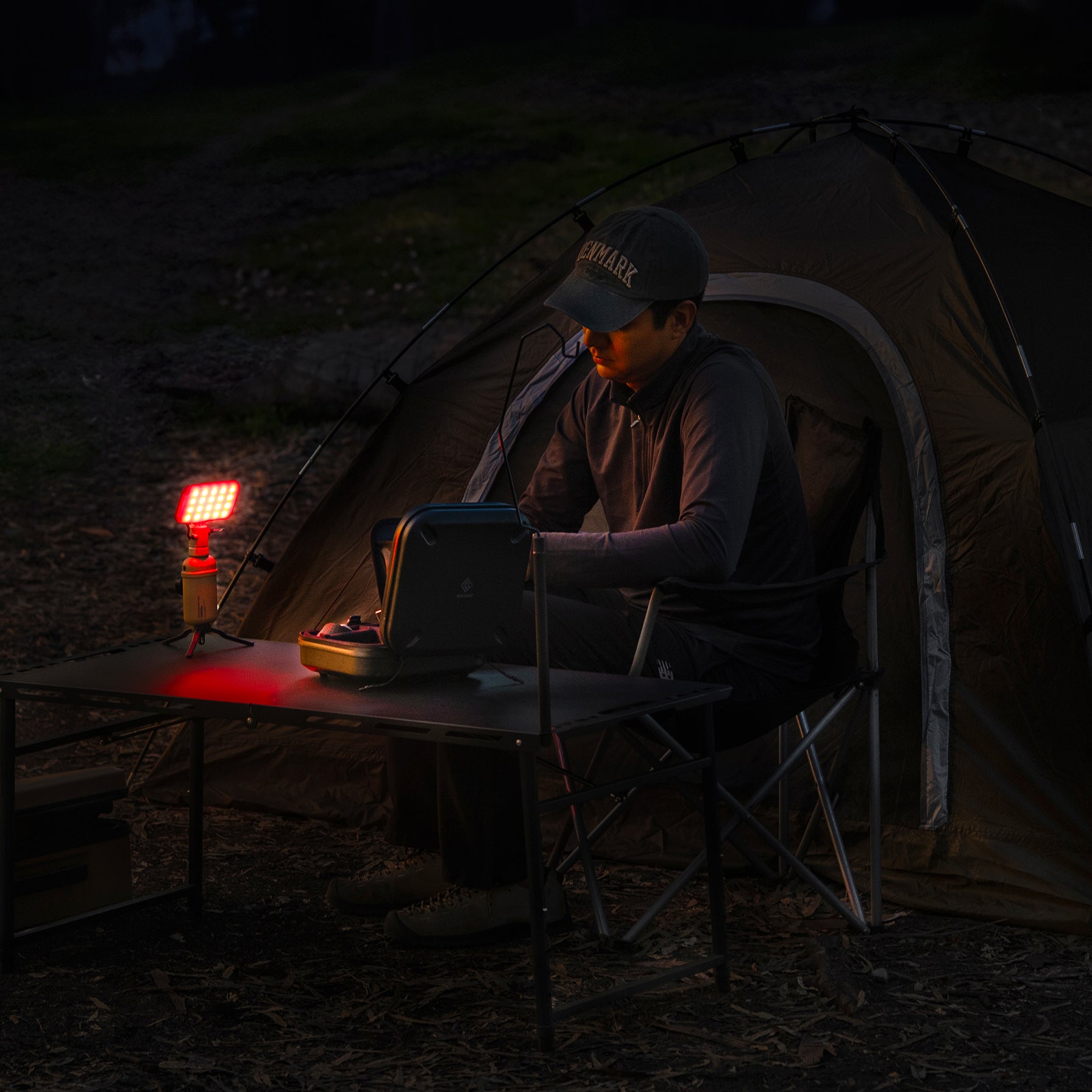 person outdoors with a 10k power bank with a flash-1 attachment and red filter light attached at night