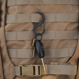 Black carabiner attached to a backpack and the carabiner has keys on them
