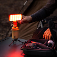 10k power bank with flash attachment that has a red light filter attached to it outdoors