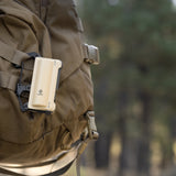 image of the nestout beige 5000n carabiner battery attached to a backpack