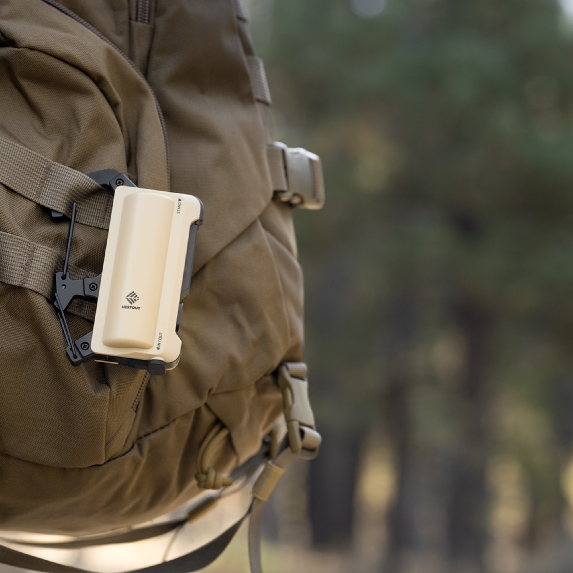 image of the nestout beige 5000n carabiner battery attached to a backpack