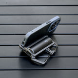 image of the nestout black 5000n carabiner battery being used as a phone stand on a table