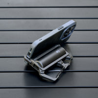 image of the nestout black 5000n carabiner battery being used as a phone stand on a table