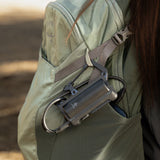 image of the nestout black 5000n carabiner battery attached to a backpack from the clip
