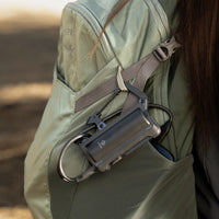 image of the nestout black 5000n carabiner battery attached to a backpack from the clip