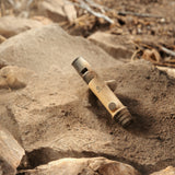 image of the nestout beige whistle light covered in dirt laying on rocks