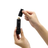 image of hands unscrewing the mouthpiece of the nestout black whistle light which shows where the AAA battery goes into