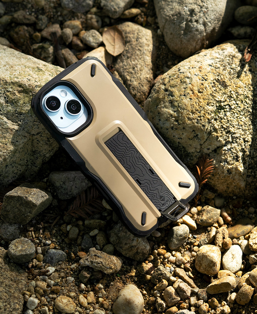 NESTOUT Beige TREKKING Hybrid iPhone 16 Case on Rocky Terrain