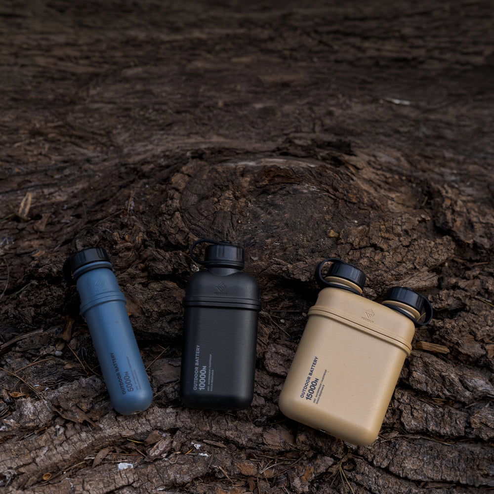 3 outdoor powerbanks laid out on a tree stump outside