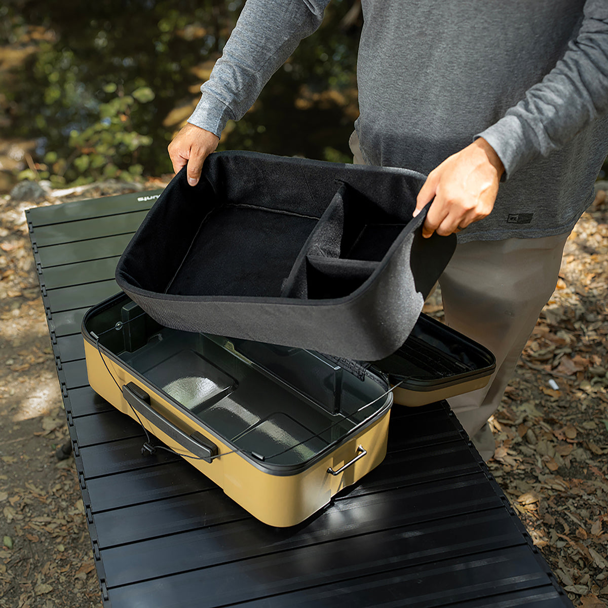 large beige gear case featuring a person holding the inner lining foam divider