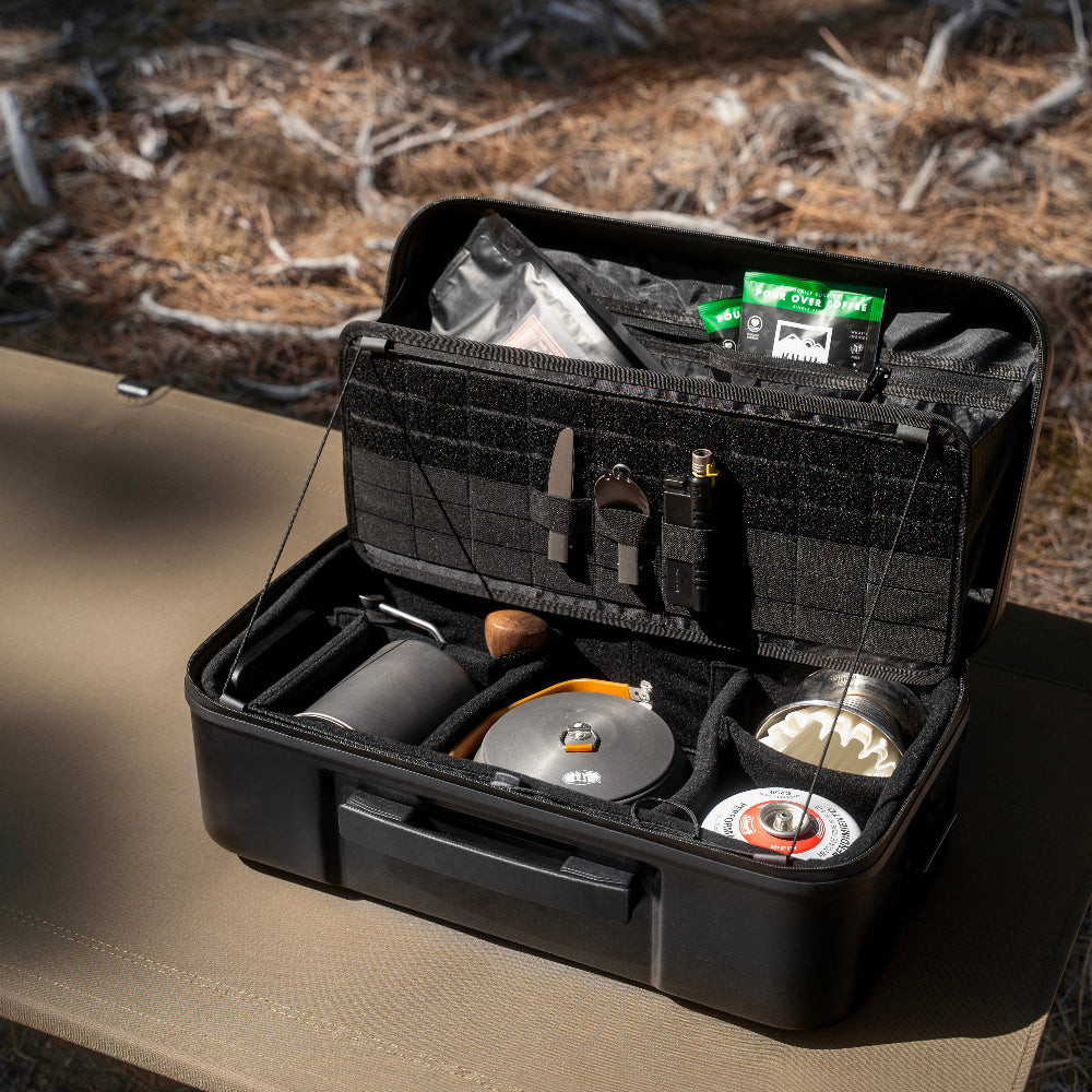 Black gear case with various compartments on a table outdoors