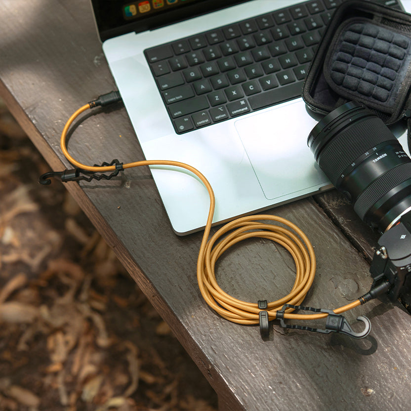 rugged beige charging cable connected to a laptop and camera