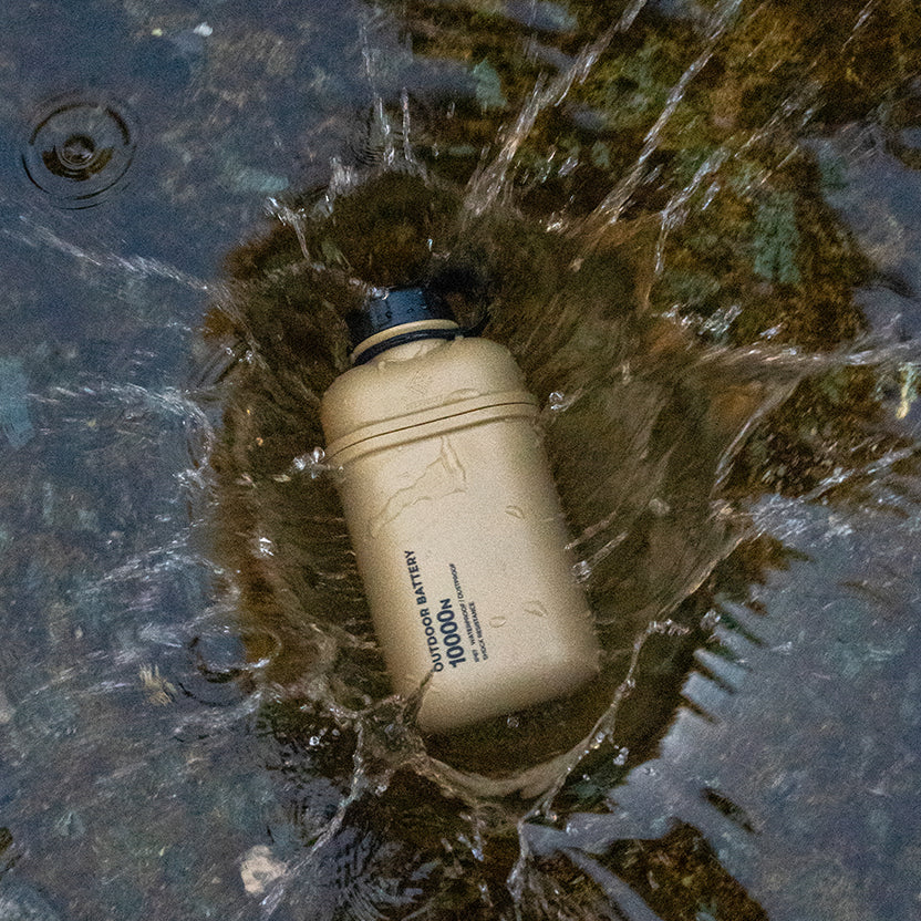 Beige 10k power bank being dropped in water