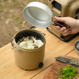 Beige cooker with cooked soup in it on top of a table