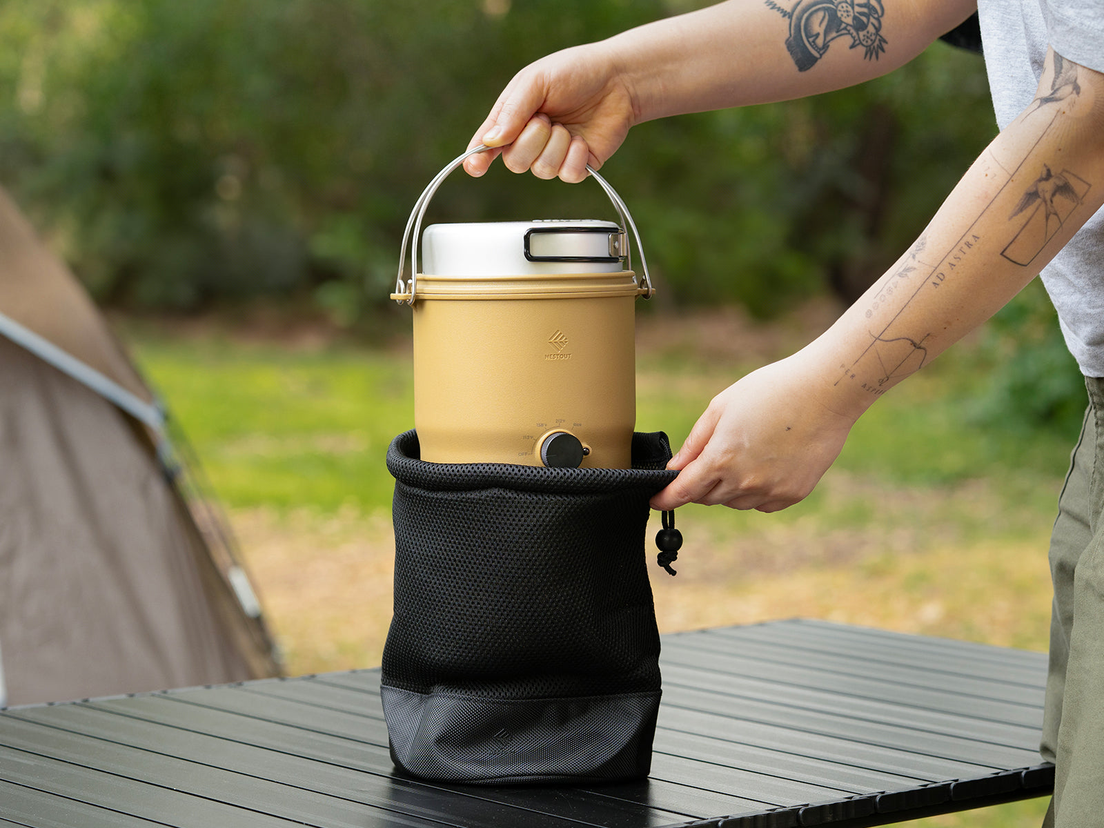 Beige outdoor cooker being taking out of provided black bag