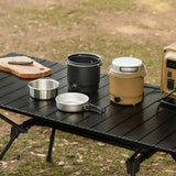 Black and beige outdoor cooker one with lid on and ne with components outside of it.