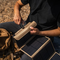 Person holding a portable solar panel device outdoors