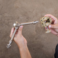 Two hands assembling a beige clamp arm