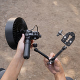 two hands attaching the clamp arm to a 5k power bank and fan