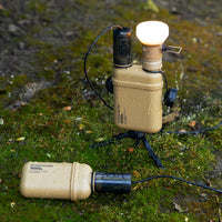 modular light setup with battery, charging cap and lamp on a wet surface