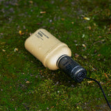 Beige outdoor battery with charging cap on a green grass background