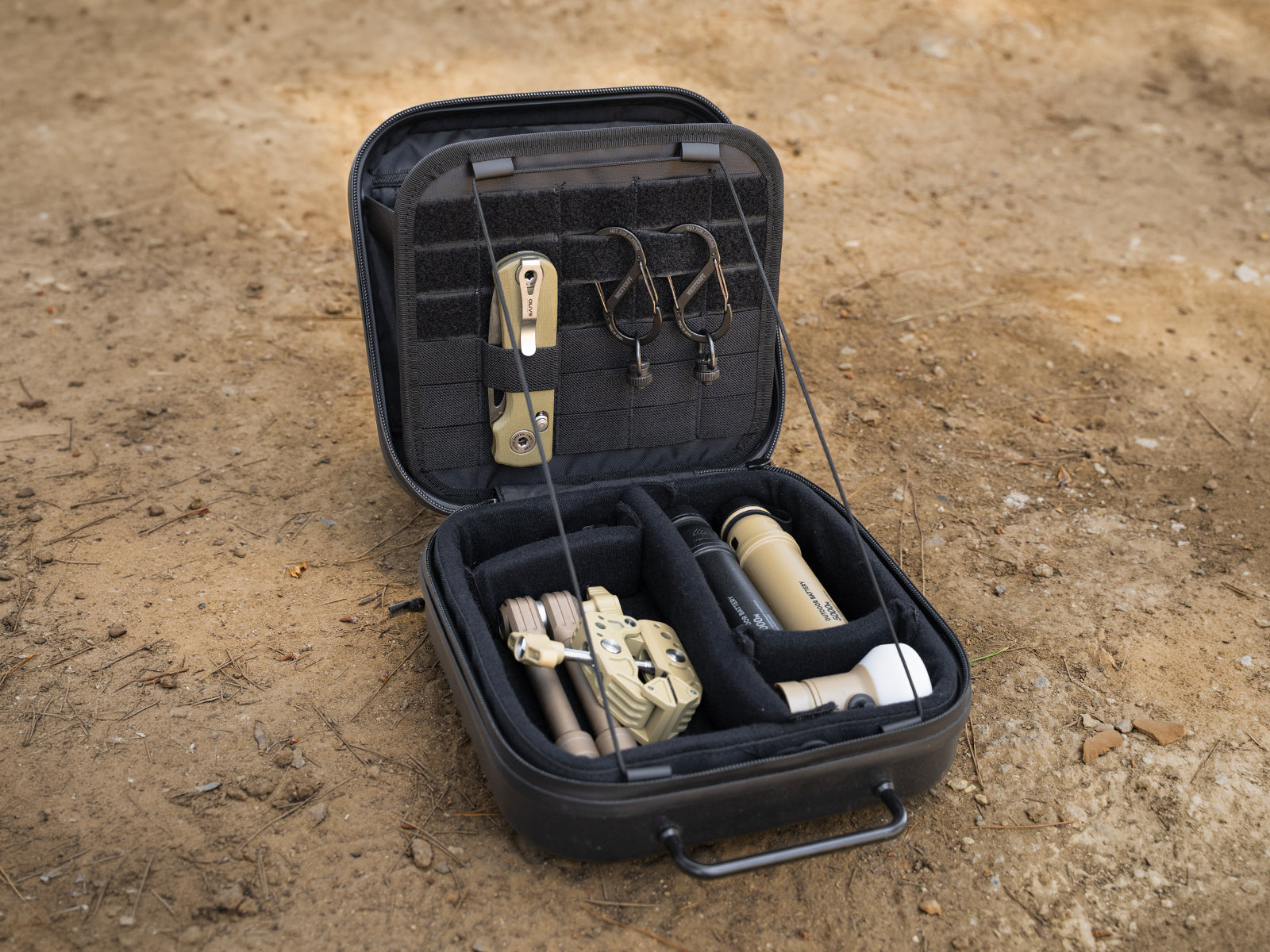 Two carabiners clipped and inside a black carrying case along with nestout power banks, clamp, lamp and knife