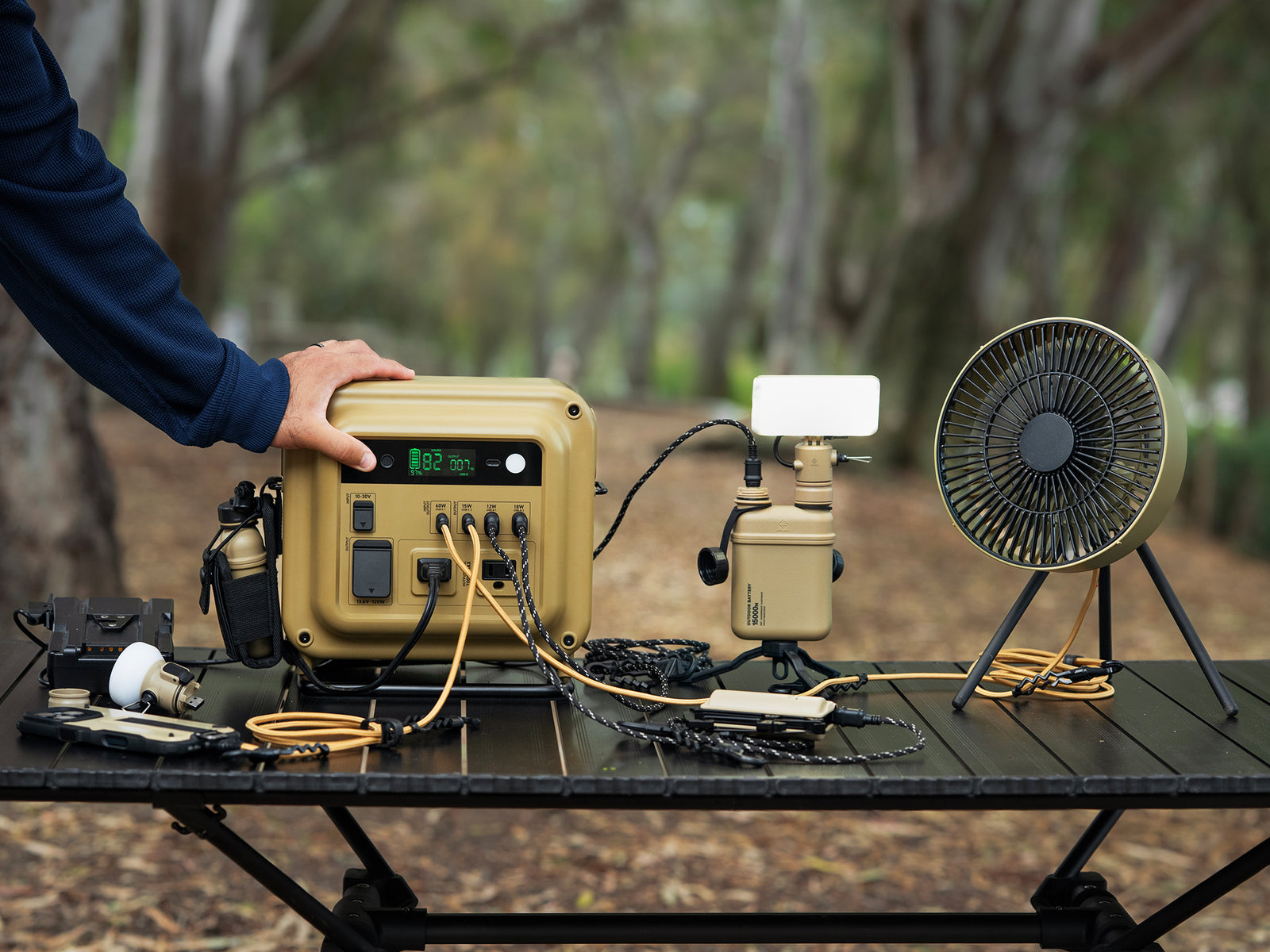 Portable power station charging NESTOUT power bank, fan, and carabiner battery.