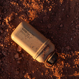 Beige colored 10000N battery pack laying in dirt 